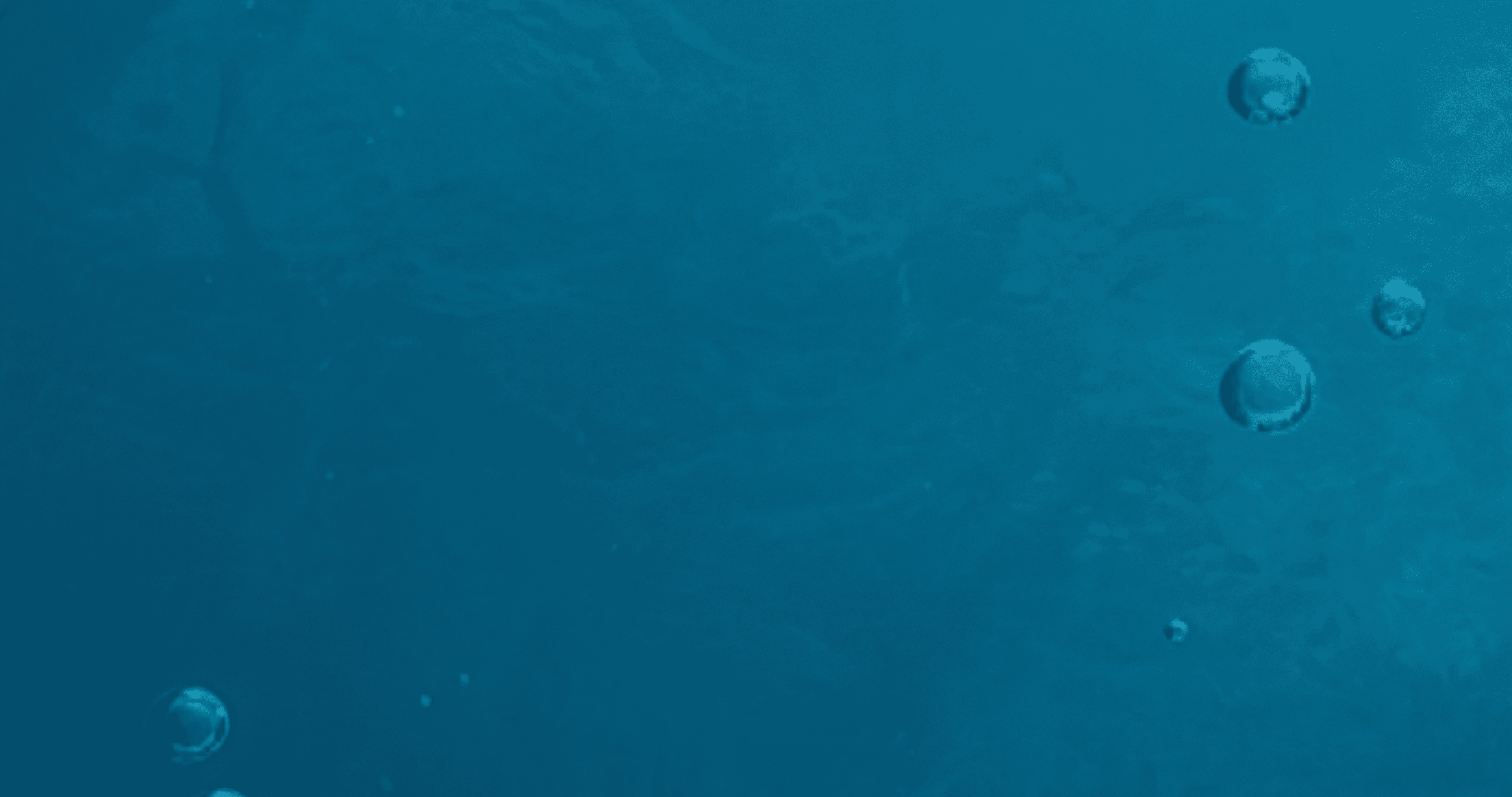 An image of bubbles rising through a blue ocean